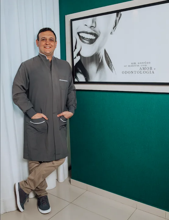 Consultório com parede verde e quadro de sorriso
